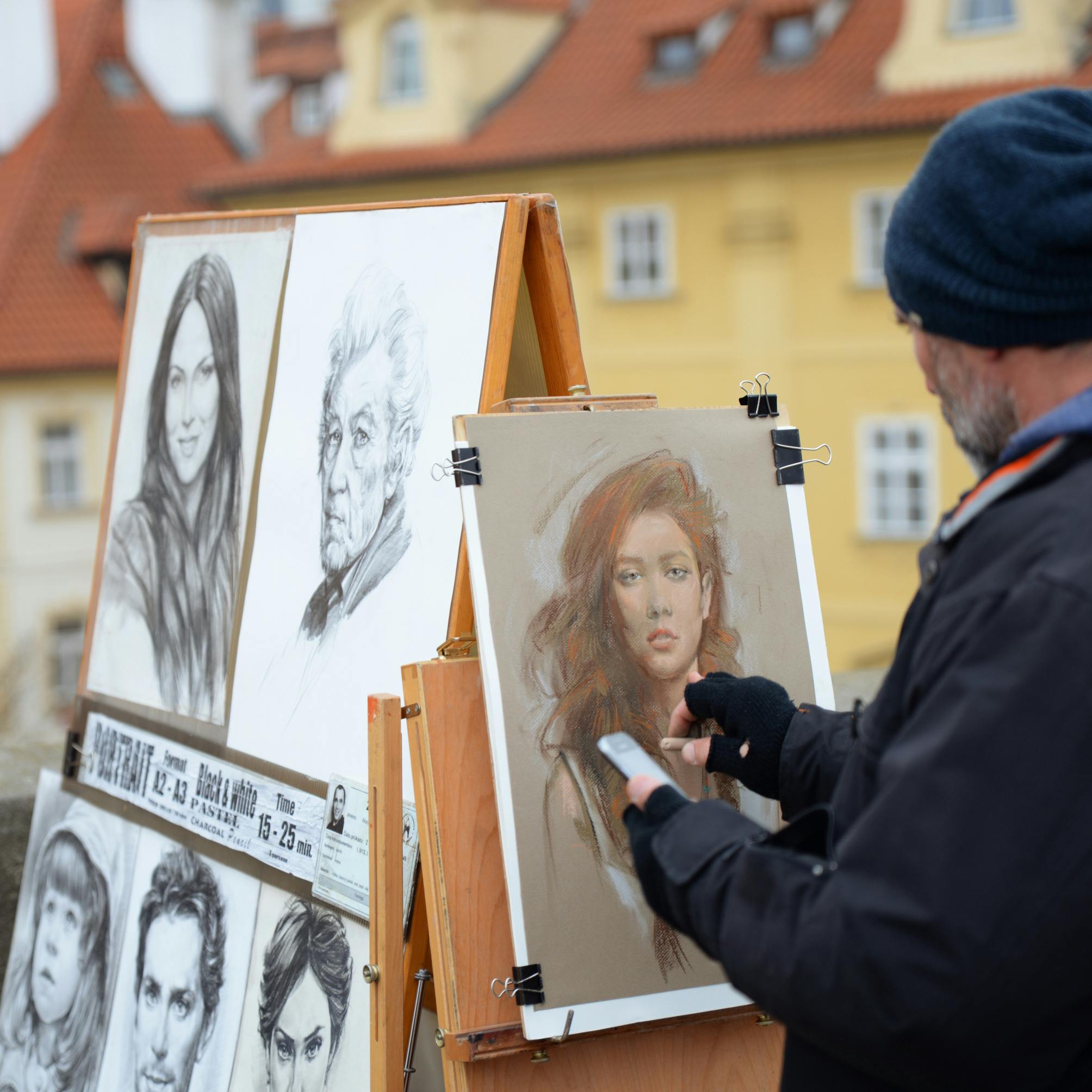 Street artist creating portraits on an easel in an outdoor setting. Vibrant art display.